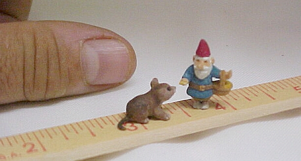 hand carved wood gnome feeding a mouse.