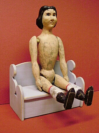 Hsnd carved Hitty Doll on her bench